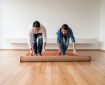 Couple unrolling a rug onto their new bamboo flooring