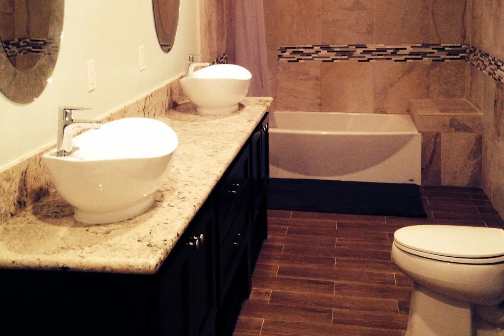 A full bathroom with wood floors