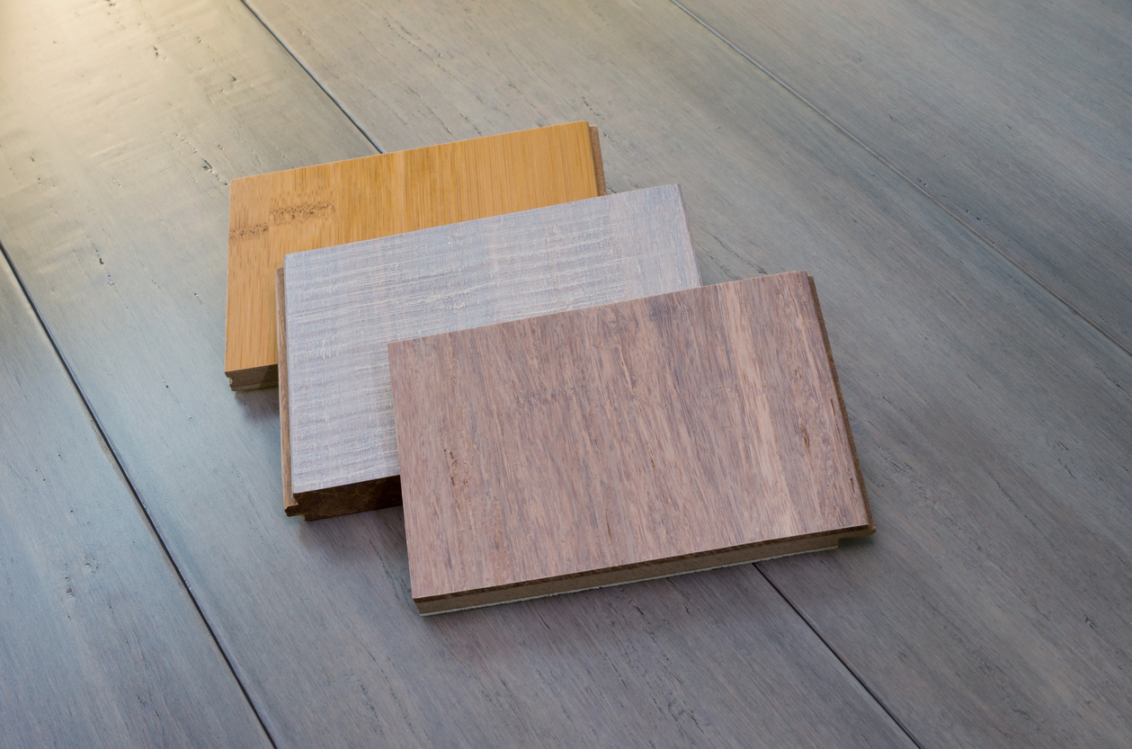 three tongue and groove bamboo flooring samples laid on top of bamboo flooring planks