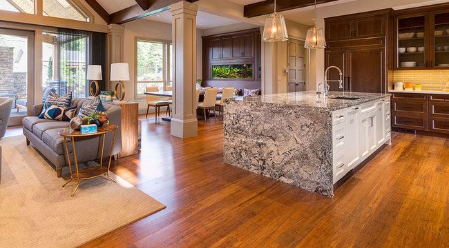 Open-concept kitchen and living area with warm brown wood flooring