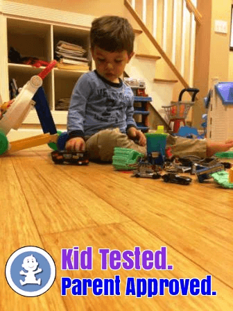 Child playing with toy cars and trucks with text over the image reading kid tested, parent approved
