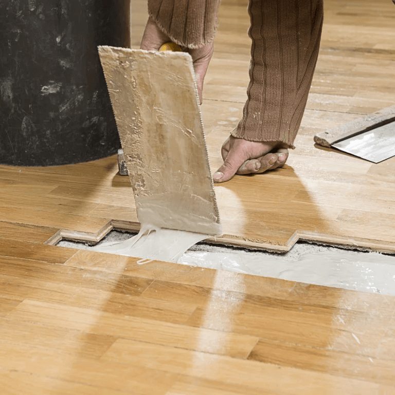 Person replacing blonde wood flooring