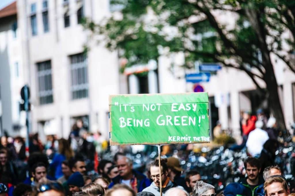 crowd of people with sign its not easy being green