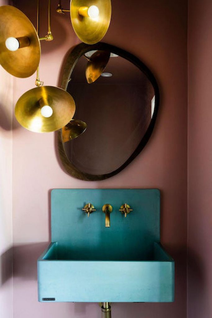 colorful turquoise powder room sink and brass light show interior trends for 2023