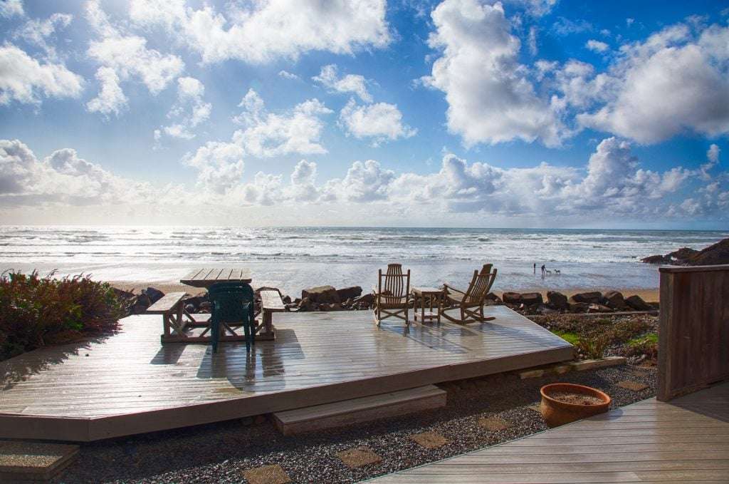 deck with furniture next to ocean