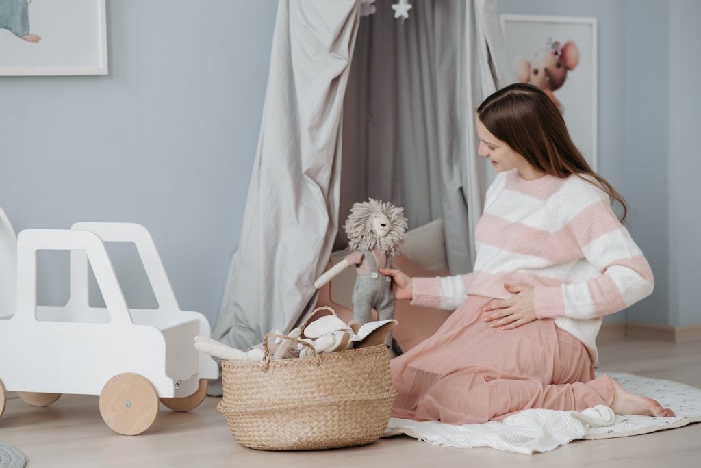 This expectant mother considers comfort in her nursery decorating ideas by using blankets as a cushion on top of her eucalyptus flooring.