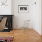 A stylish chair is featured on a patterned bamboo floor. In addition to being the most durable flooring, bamboo flooring like this brings traditional beauty into any home.