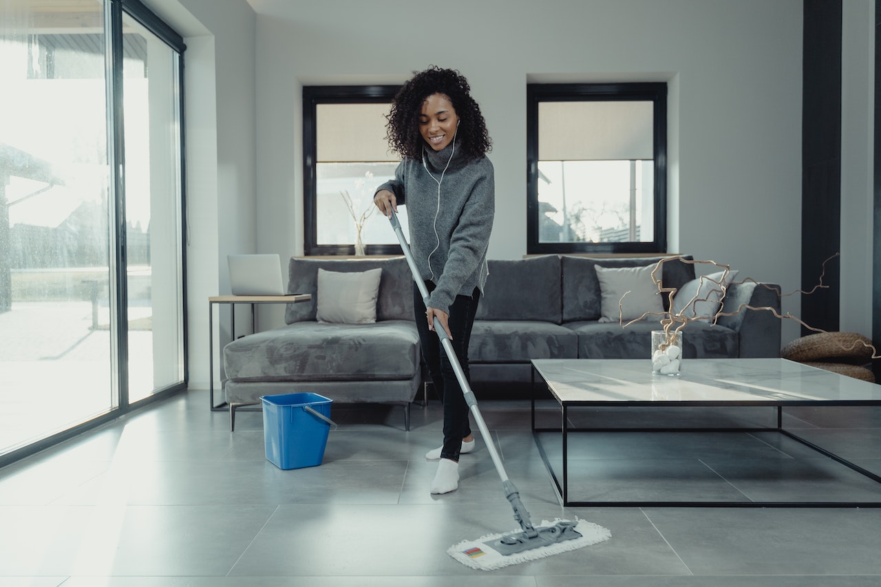 A woman mops her floor to improve indoor air quality.